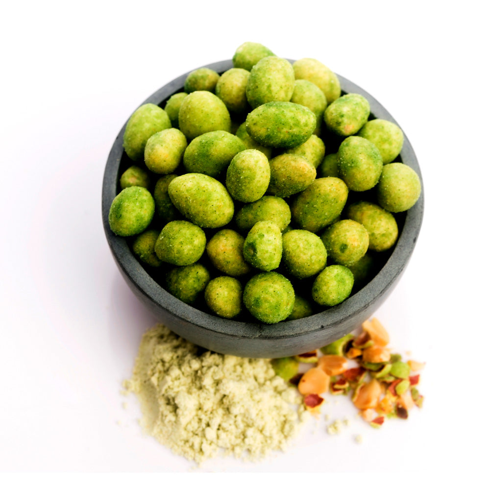 Bowl of green wasabi peanuts with a white background