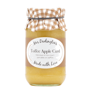 Jar of toffee apple curd with a checkered lid on a white background