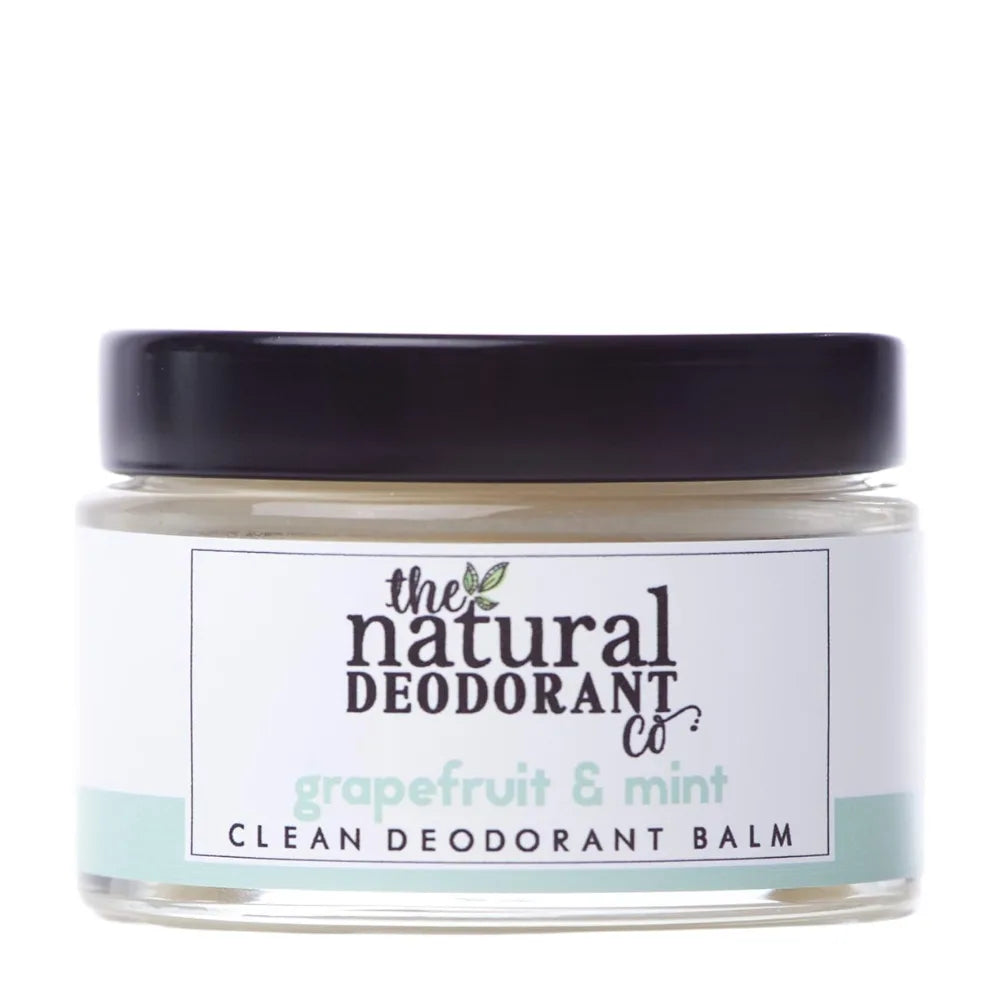 Clear jar of 'The Natural Deodorant Co.' grapefruit & mint deodorant balm on a white background