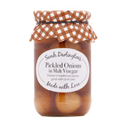 Jar of pickled onions with a checkered lid on a white background