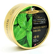 Simpkins Mixed Mint Drops tin with gold lid and green mint leaves on a white background