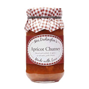 Jar of apricot chutney with a checkered lid on a white background